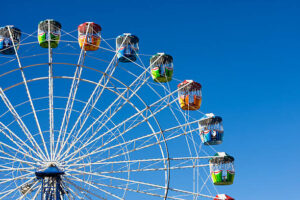 A colourful ferris wheel against a deep blue sky.
